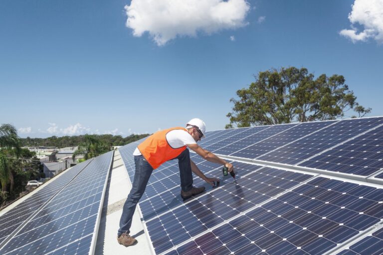 Man fixing solar panels to a roof